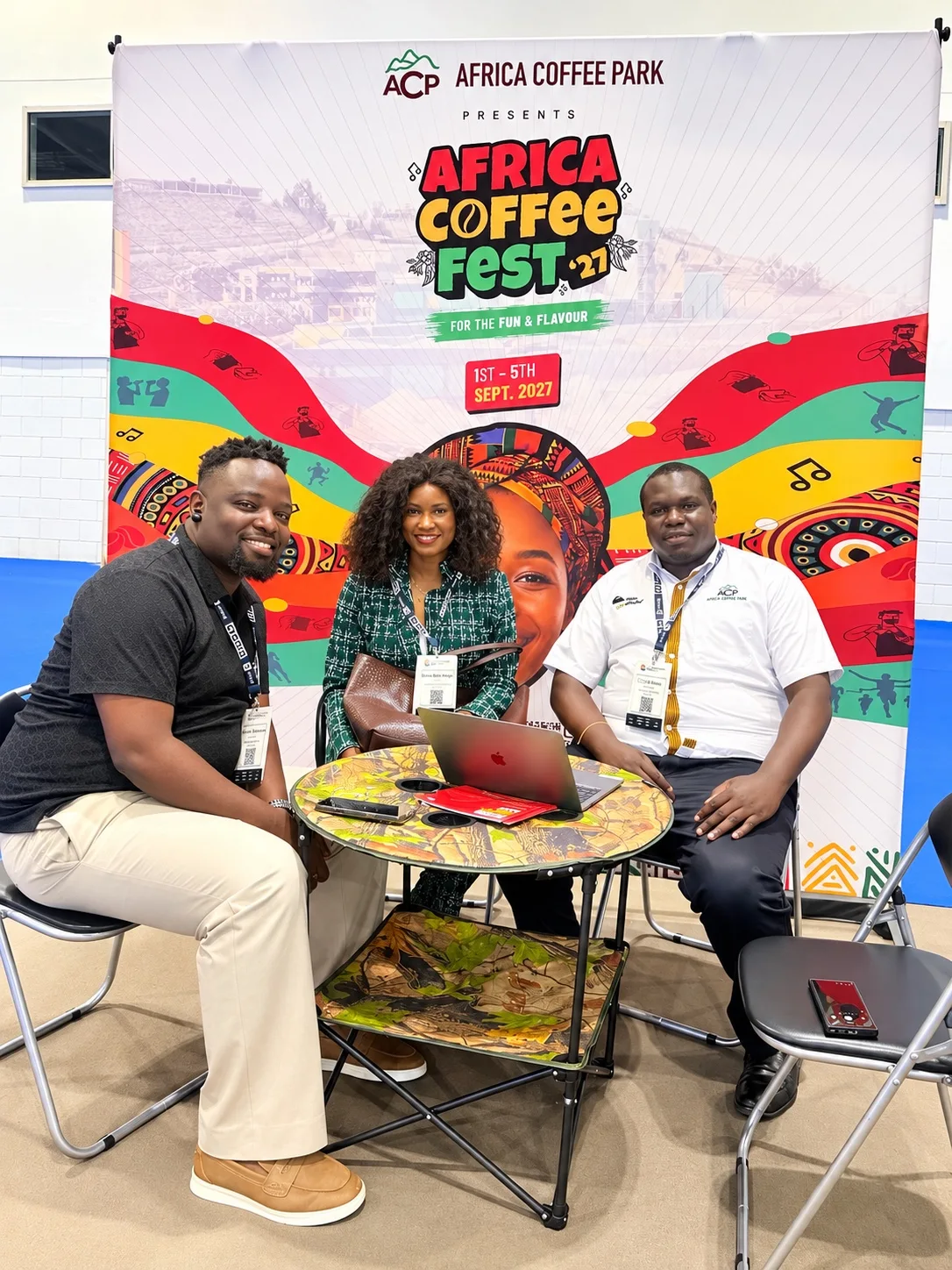 Doris Beth Atigo seated with exhibitors at the Africa Coffee Park stand.