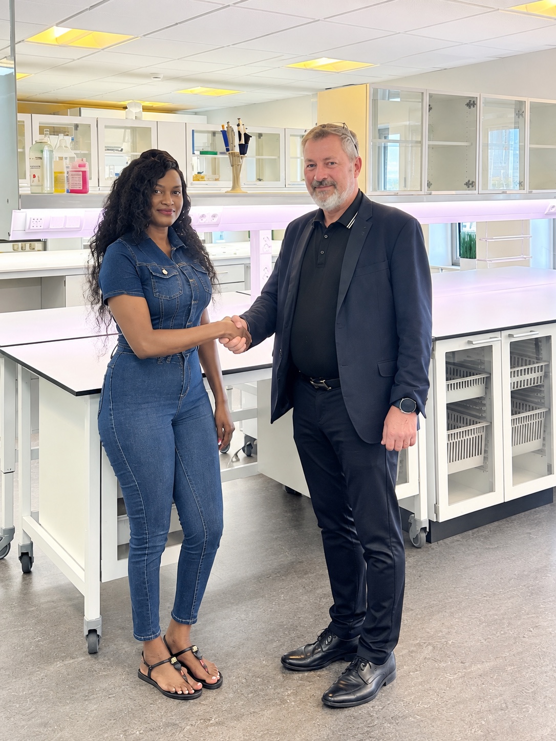 Crossgates co-founders Doris Beth Atigo and Reidar Robdrup Rasmussen shaking hands in celebration of the company’s Uganda registration.