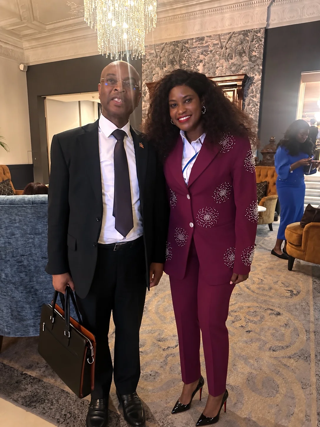 Doris Beth Atigo, wearing a burgundy suit, standing with a fellow summit participant.
