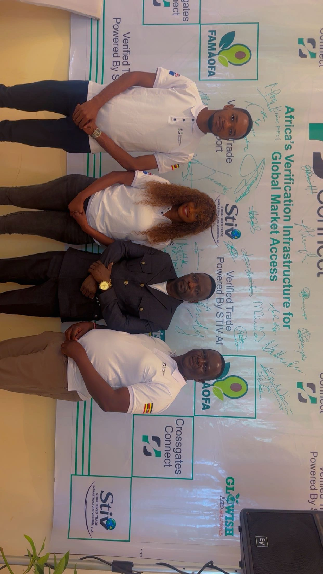 Crossgates team with Dr Hillary Emmanuel Musoke Kisanja at the Uganda launch, in front of the Crossgates and FAMAOFA backdrop.